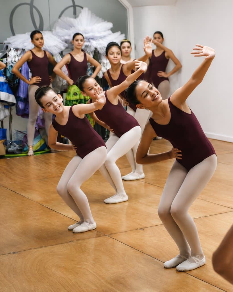 Alumnas en plena clase de ballet, ensayando frente al espejo